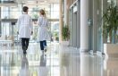 rear view of two doctors walking through a modern, sleek clinic hospital, engaged in conversation. full height perspective convey a sense of professionalism and teamwork, concept o rear view of two doctors walking through a modern, sleek clinic hospital, engaged in conversation. full height perspective convey a sense of professionalism and teamwork, concept o